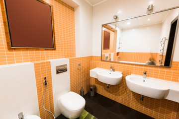 close up view of modern bathroom in orange and white colors
