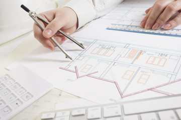 Architects working on blueprint, real estate project. Architect workplace - architectural project, blueprints, ruler, calculator, laptop and divider compass. Construction concept. Engineering tools.