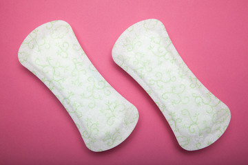 Close up, two sanitary pads on a pink background.