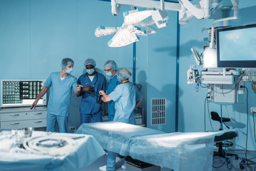 four multicultural surgeons in operating room