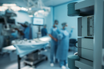 doctor helping to wear surgical uniform on blurred background
