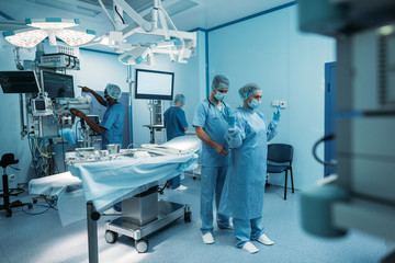 doctor helping to wear surgical uniform in operating room