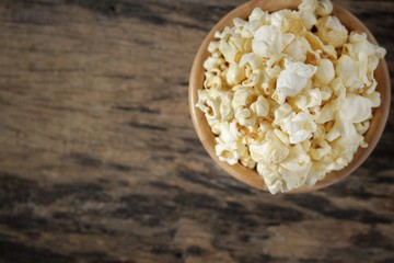 Top view, Butter popcorn in the wooden bowl on the wooden table