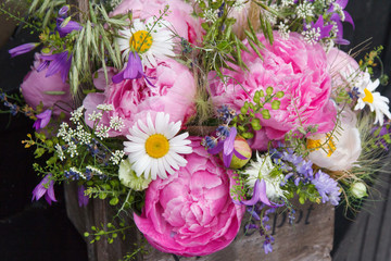 Obraz na płótnie Canvas Flower arrangement, bouquet with pink peony, chamomile and green plants closeup. Flowers background