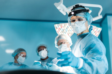 four multiethnic doctors in operating room