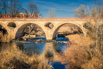 Fototapeta na wymiar Zulema bridge, built over Henares River as it passed through Alcalá de Henares on an autumn afternoon.