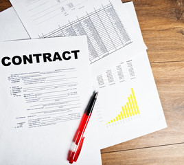 Pen and contract papers on wooden desk
