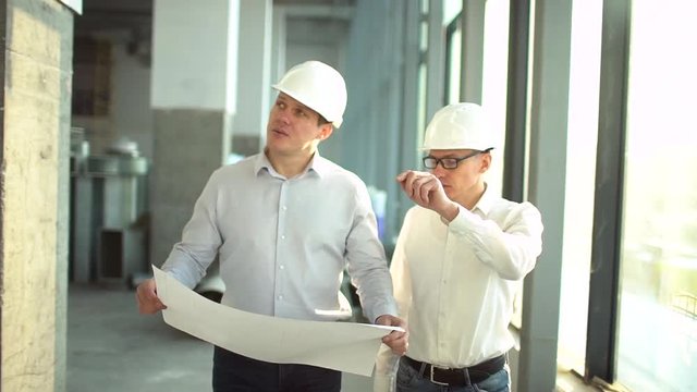 Two engineers meet at construction and consult building project. Two engineers meet at construction and consult building project. slow-motion
