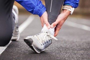 Cropped shot of a young man holding his ankle in pain sprain a foot.
