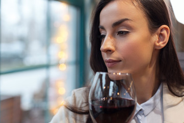 Wine bouquet. Concentrated attractive beautiful woman posing with glass of wine while turning from camera and thinking