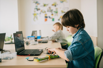 kid constructing robot at stem education class