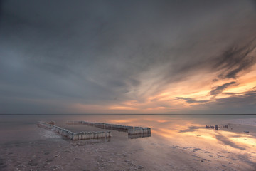 A beautiful light with a smooth sky over a salt lake with a smooth water and a reflection of the sky