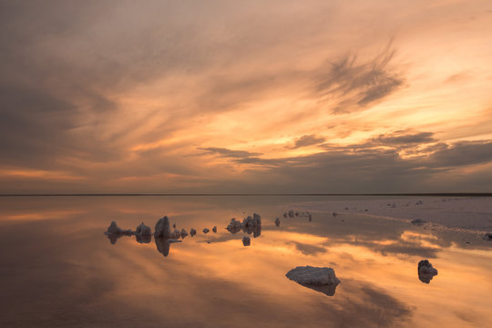 A beautiful light with a smooth sky over a salt lake with a smooth water and a reflection of the sky