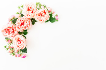 Stylish frame made of pink roses, buds and petals on white background. Floral composition. Flat lay, Top view.