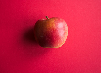 ripe red apple on a red background