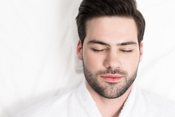 Obraz premium close-up view of handsome bearded man in bathrobe relaxing in spa salon