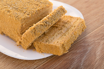 Traditional Russian baked honey cake, sliced on white plate