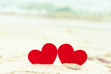 Fototapeta premium Two red hearts on the summer beach. Love, Wedding and Valentines day concept.