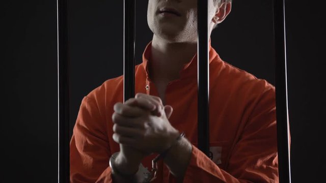 Handcuffed prisoner eagerly waiting for appeal court verdict, feeling nervous