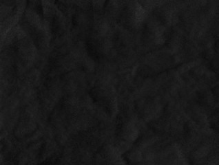 Black wrinkled paper texture. Dark textured surface background