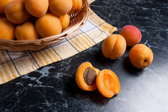 Fresh organic apricots in basket. Group of harvested apricots in basket..