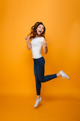 Fototapeta na wymiar Full length image of Happy brunette woman in t-shirt jumping