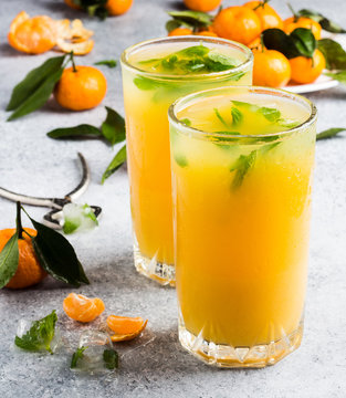 Tangerine juice in glasses on light background