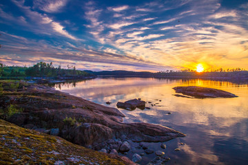 Die Natur Finnlands. Sonnenuntergang am Ufer des Sees. Küste. Abendwolken. Natur des Nordens. Sommer in Finnland.