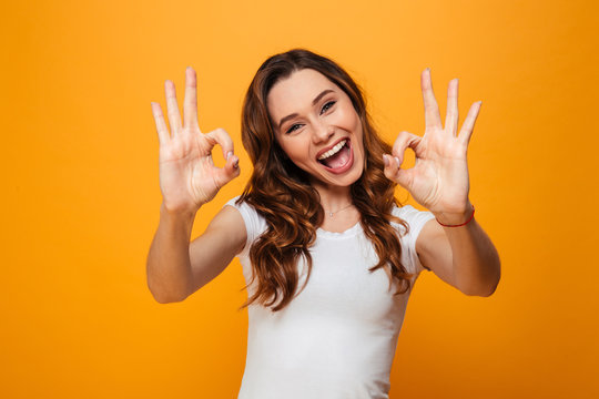 Happy brunette woman in t-shirt showing ok signs
