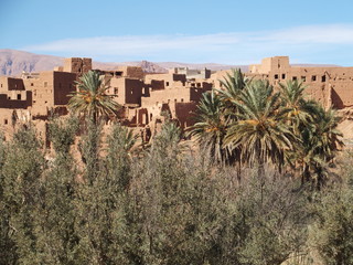 Obraz premium Old town of Tinghir, green palm oasis and rocky Atlas Mountains range landscape in southeastern Morocco