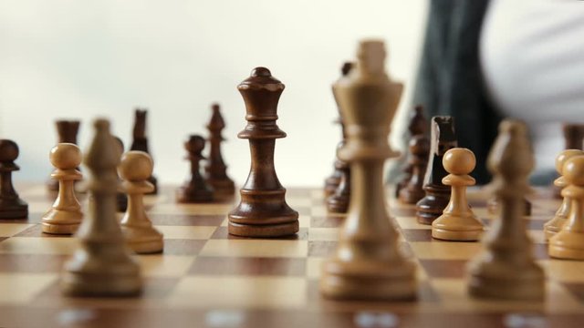 Woman moving chess figure with team behind - strategy, management or leadership concept