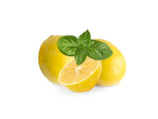 Two lemons and halves isolated on white background. Ripe lemons with basil close-up. Background...