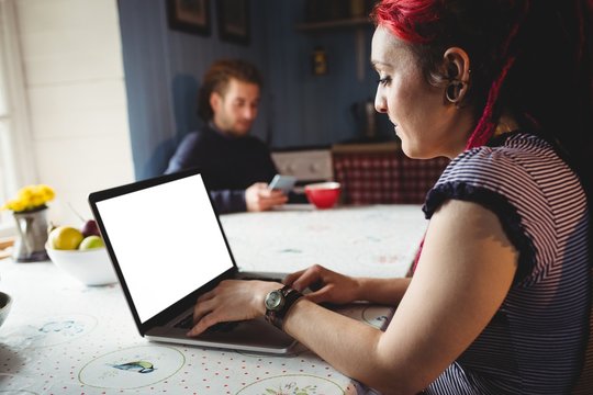 Hipster woman using laptop at home