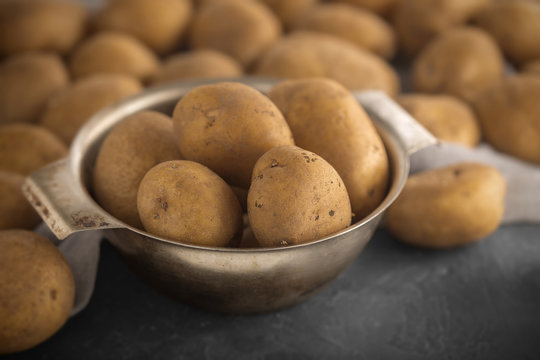 Raw potato food. Pile of fresh potatoes lying  on old concrete table. Concept of food background. Free place for text, top view.