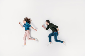 Fototapeta na wymiar top view of couple pretending to run isolated on white