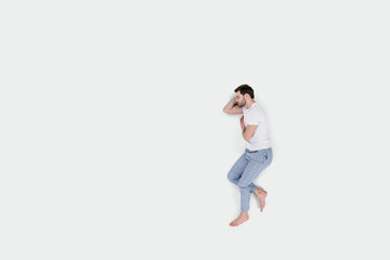 top view of sleeping young man in pajamas isolated on white