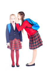 School girlfriends in uniform gossiping on white background