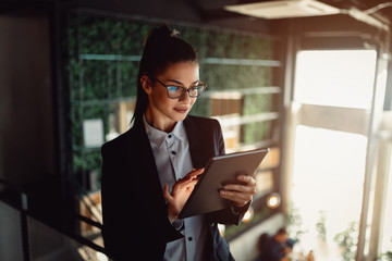 Young businesswoman using tablet computer. Girl surfing the internet.