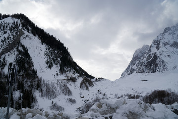 Granite mountains covered with snow and winter forest near Mont Blanc Alpes, Italy