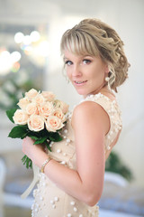 beautiful blonde bride with a bouquet of white roses