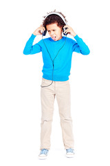 Portrait of cute curly-haired Latin American boy annoyed with music in his headphones