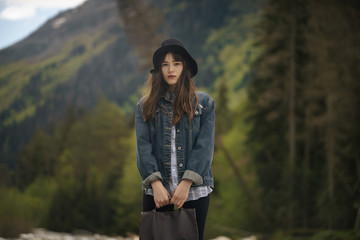 stylish hipster gypsy boho woman posing in hat with windy hair, in fringe poncho and accessory....