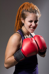 Young woman boxer with dreadlocks with clenched teeth