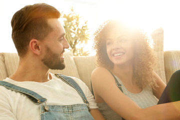 Newlyweds sitting on the couch in a new apartment.