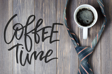 Men's tie and coffee in a white Cup on wooden background. Handwritten text - Coffee time.