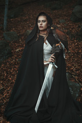 Black hooded woman with sword and hawk