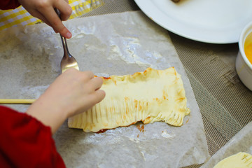 children prepare pies from bacon and cheese