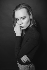 Obraz premium Posing in darkness. Black and white photo of beautiful cute blonde woman. Woman in black turtleneck. Relaxing in the wavy world of dreams. Concept of business, new opportunities, partnership.