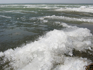 The awakening of nature. The lake is free of ice. In the foreground, beautiful ice-frozen waves.