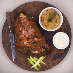 Restaurant dish - large baked pork knuckle on a wooden tray